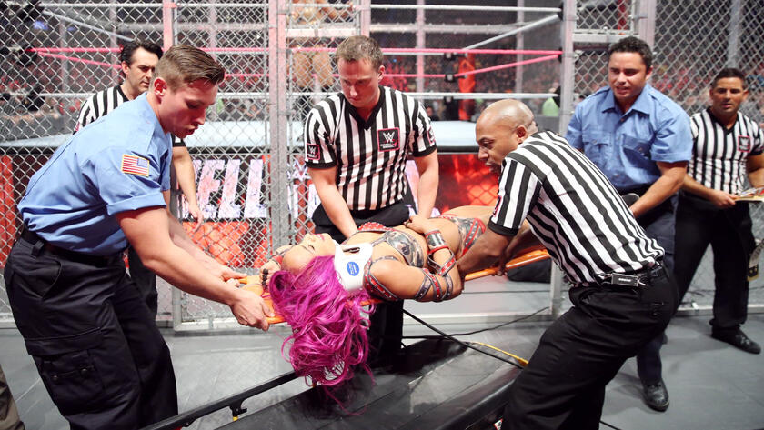 Following devastating attacks by Flair, Sasha is taken away on a stretcher. 