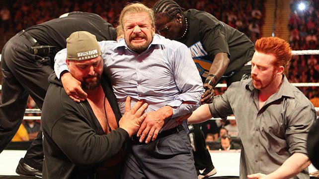 Triple H being helped out of the ring after Brock Lesnar's attack